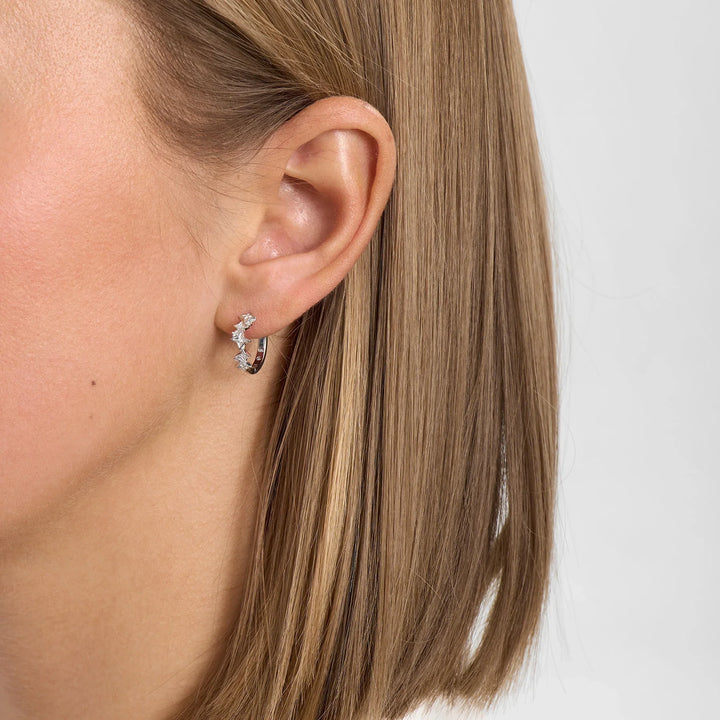 Silver earring with clear stones, half hoop, shown on the ear from the side, model 2117196_1M