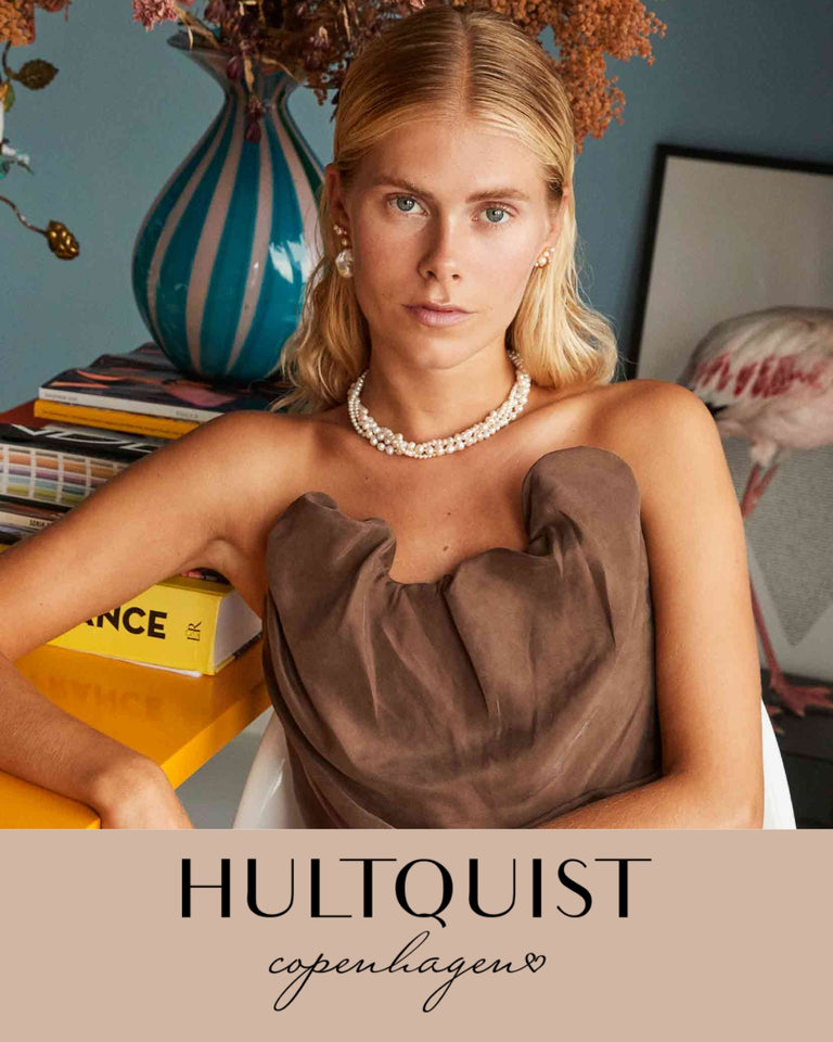 Hultquist smykker modelbillede, kvinde med perlehalskæde og ørestikker, brun top, forside