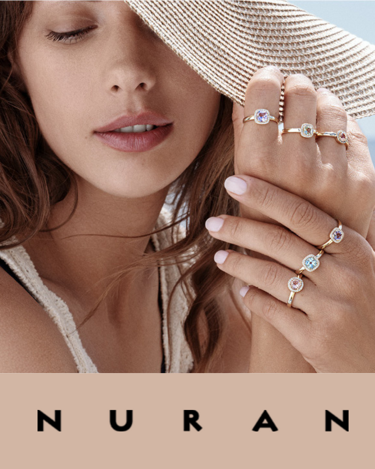 Nuran smykkekollektion, model viser guld ringe med farvede sten, forsidebillede.