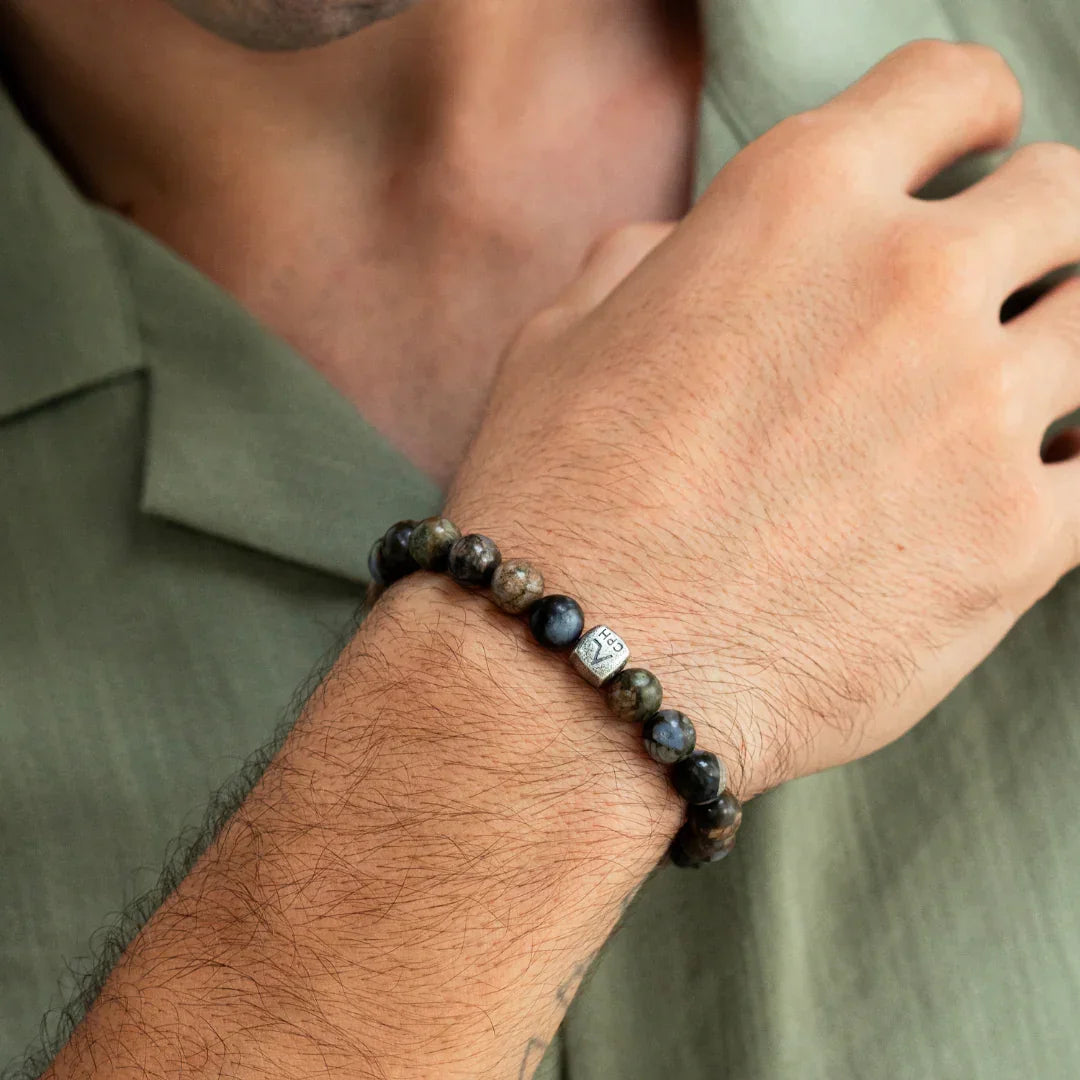 Alexander Lynggaard Bracelet Glaucophane 8mm shown on a man's hand, beads in blue-brown shades. Model C01180-001.