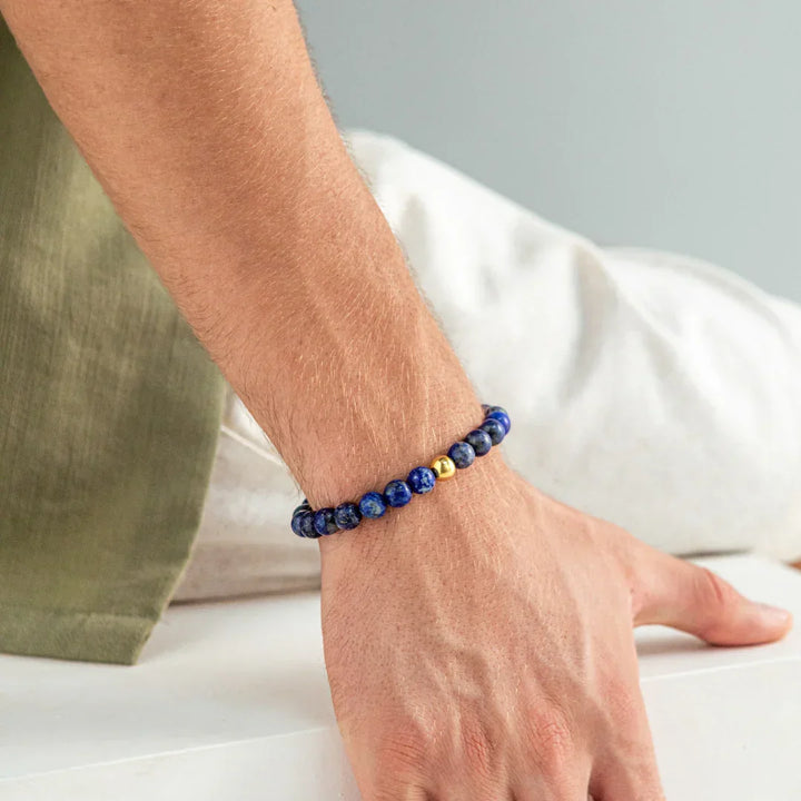 Alexander Lynggaard Armband Lapis Braided 8mm worn on men's wrist, dark blue beads with gold detail, Model B00163-1