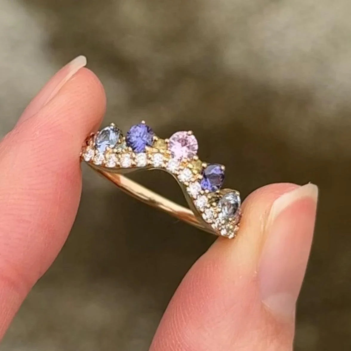 anpe-atelier-josephine-ring-with-pastel-sapphires shown close-up, curved design with multicolored gemstones in gold. Model 2458-pastel-001.