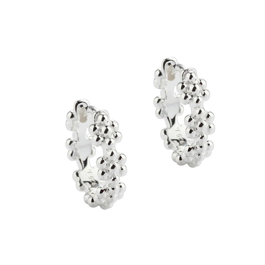 Aqua Dulce Lots of Flowers Hoop Silver 13mm 5705–1 shows a pair of silver hoops with floral details. Model 5705–1.