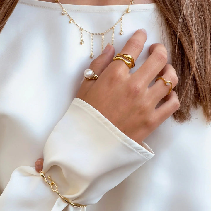 Aqua Dulce Wave Ring in gold plated seen on hand with other rings, elegant and organic design. Model 6626-001
