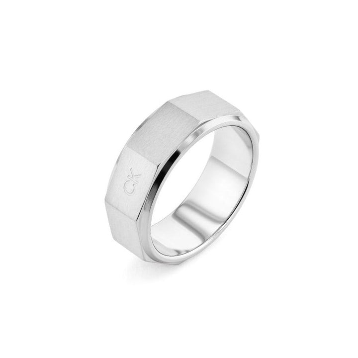 Calvin Klein Latch Ring shows a wide, silver-colored men's ring in brushed steel with a faceted edge. Model 35000316-001.