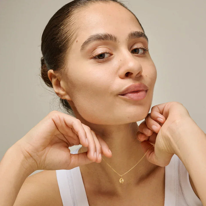 Enamel Four Leaf Clover necklace in gold-plated silver worn by woman with white top, Model n138gm-1
