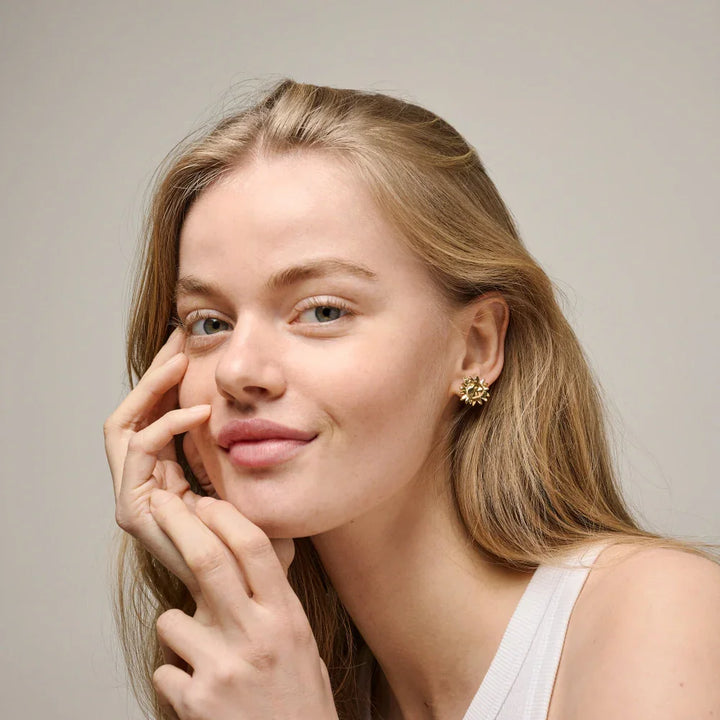 Enamel Large Sunshine Stud shown on model, golden sun-shaped studs in the ear. Model e421g-2
