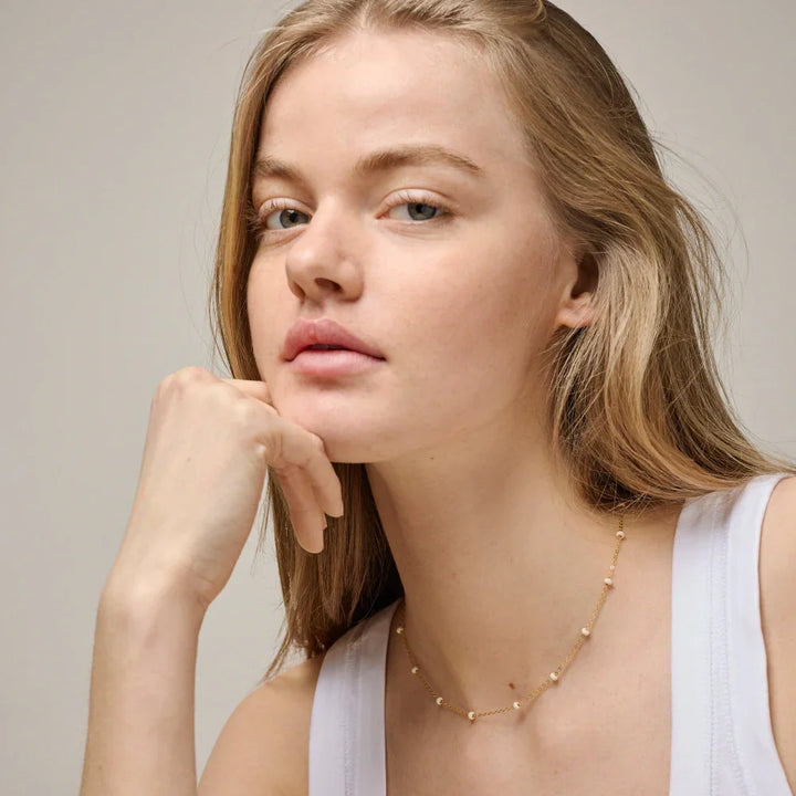 enamel-lola-bold-necklace-daisy-in-gold-plated-sol n137g daisy image shows model with simple, gold-plated necklace with fine details. Model N137G