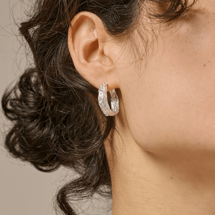 enamel Nela silver hoops 20 mm worn here in the ear, matte texture and organic design, Model e370sm-e370sm-2