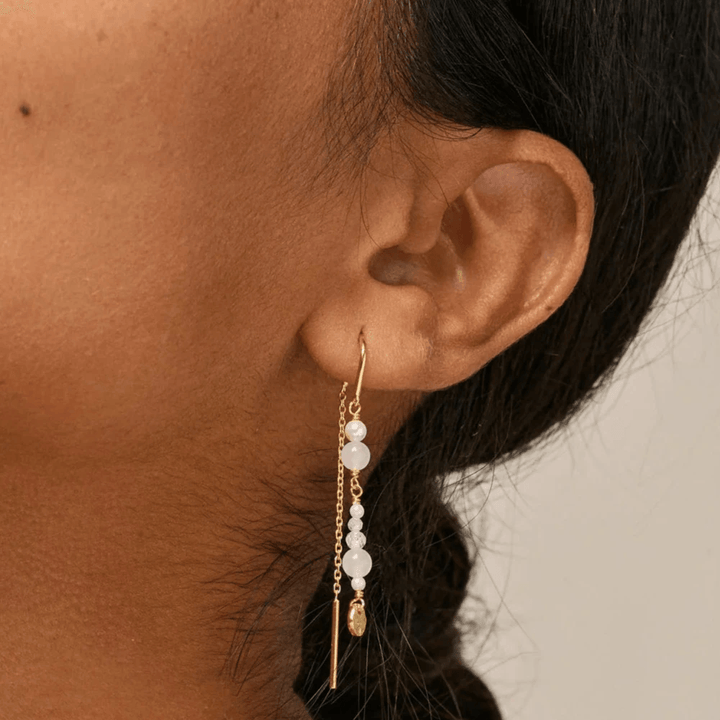 Enamel Sofia Earings White and Pearls shown worn in the ear, long gold-plated earrings with white pearls. Model e282g-white-2