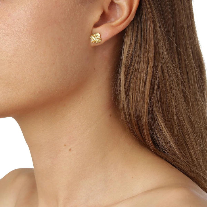 Flora Danica Four-leaf clover ear studs 18kt gold appear on the ear, elegant clover design in shiny gold. Model flc-stpc-18k-g-2