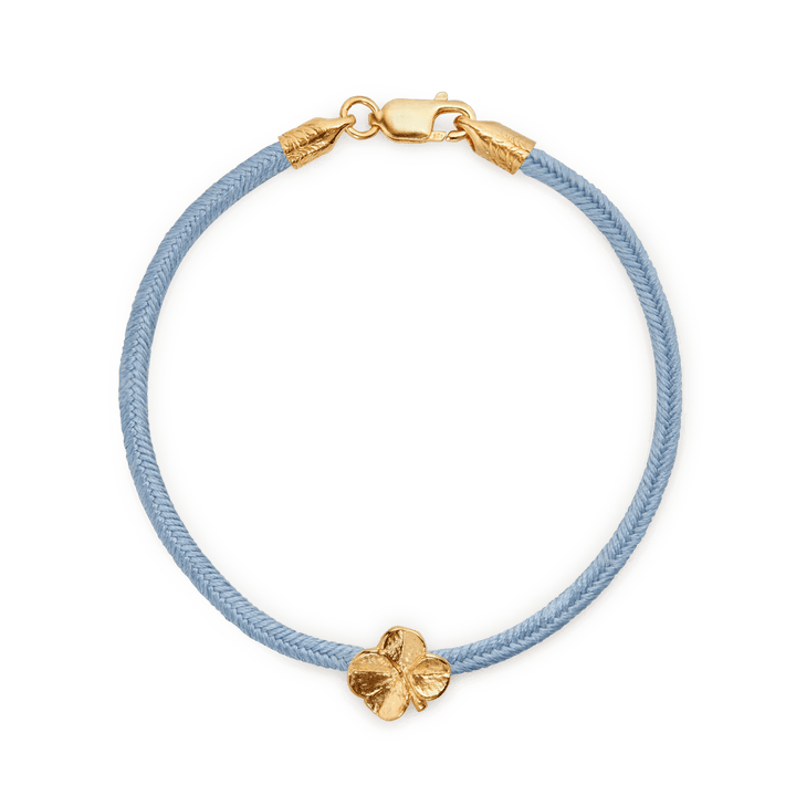 Flora Danica Four Leaf Clover Silk Bracelet Blue Gold Plated shown close up with blue silk cord and four leaf clover charm in gold. Model907-flc-silk-blue-g-001-1.