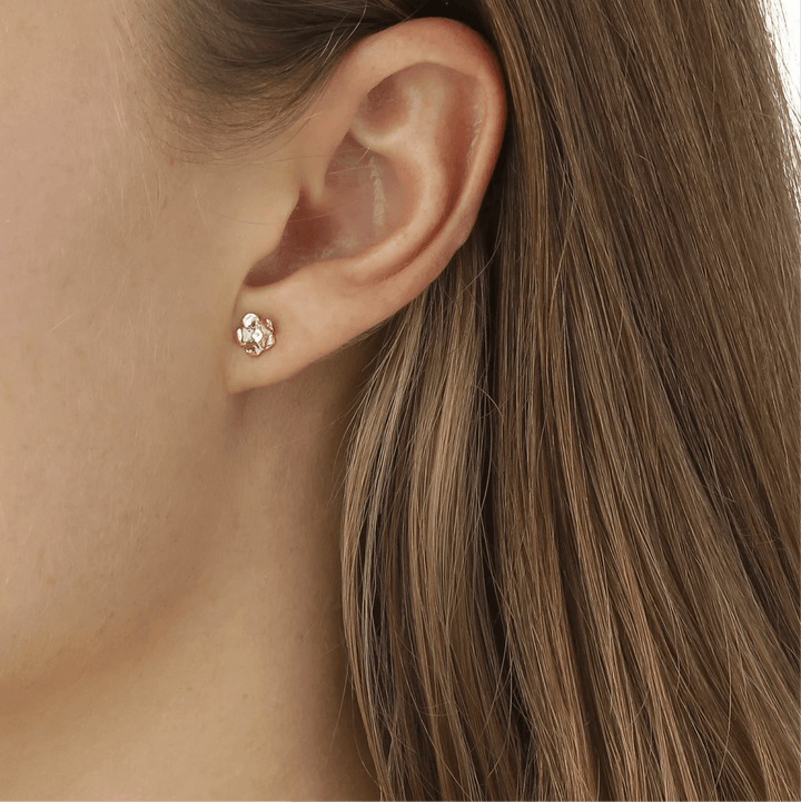 Flora Danica Forget small ear studs 18kt gold shown on ear, detailed floral design. Model fmn-stpc-18k-g-2