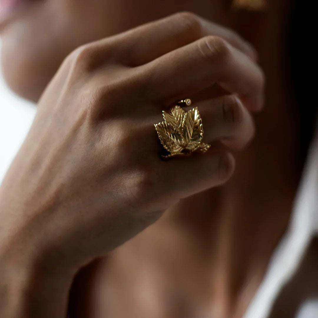 Flora Danica Roseleaf Statement Ring with diamond is displayed on one hand, detailed in shiny gold finish. Model stri-g-001-1