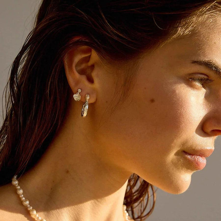 Hultquist Copenhagen Lainey Petite silver stud earrings shown on model with pearl chain in sunlight. Model S08610S-2