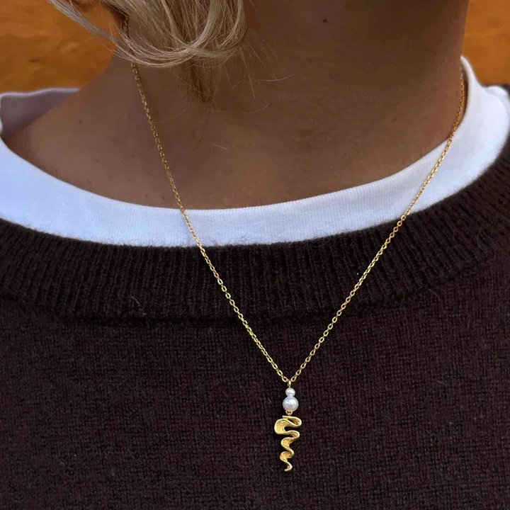 Hultquist Hedda necklace gold-plated with twisted pendant and pearl, worn close around the neck. Model S08653G-2