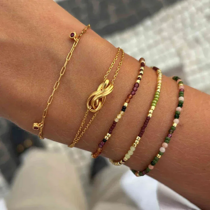 Hultquist Rowen Wrist bracelet with golden knot and colored pearl chains in sunlight. Model S08641G-2