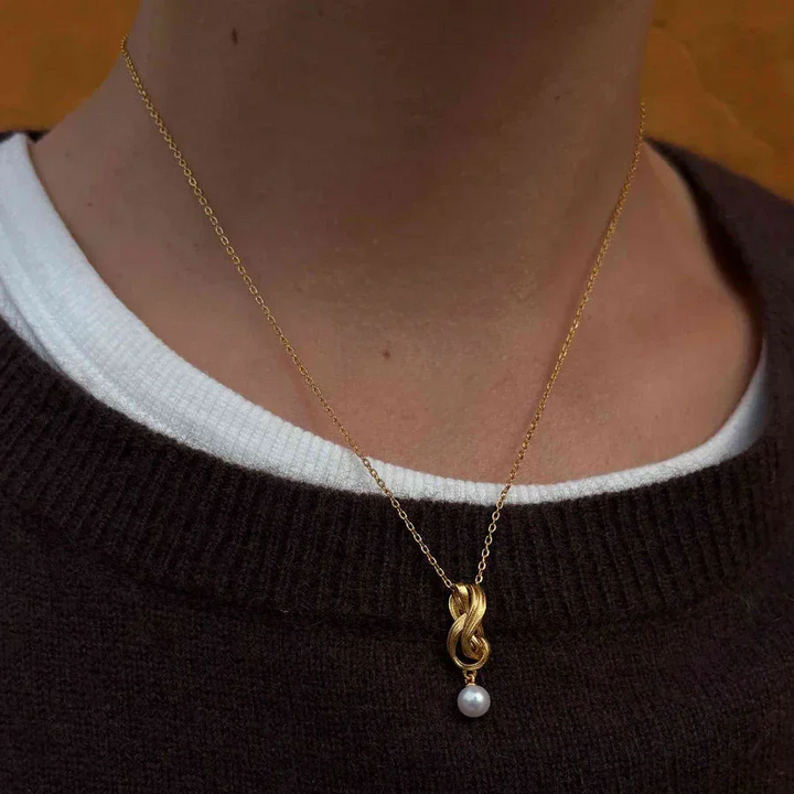 Hultquist Tiril Necklace Gold plated seen on model, elegant gold chain with braided pendant and pearl. Model S08646G-2.