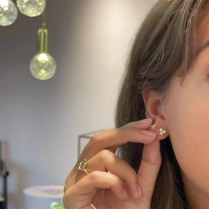 The Jeberg Jewelery Cordelia Triple Pearl Stud is shown here worn in the ear of a woman, with three white pearls. Model 52715-2