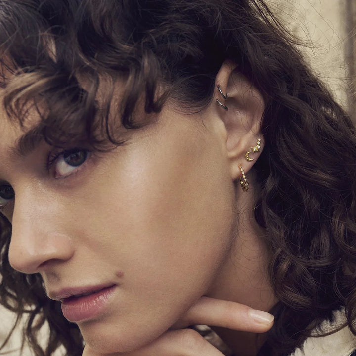 Maanesten Arlette gold-plated hoops are shown worn by model, elegant detail in gold. Model 10020a