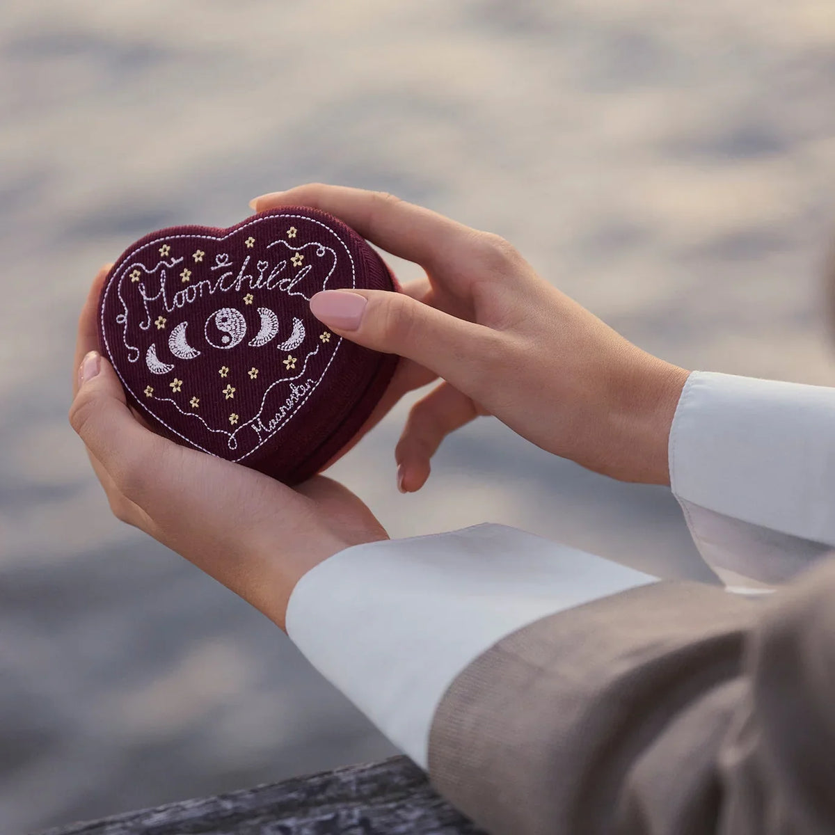 Maanesten Heart Jewelry Box Maroon appears in hands outdoors, dark red heart shape with embroidery. Model 2026-4207-1