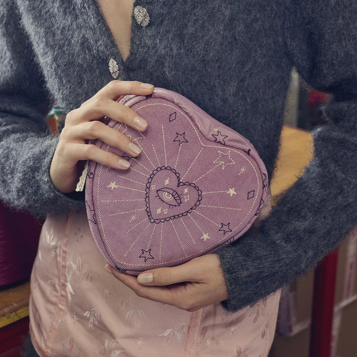 maanesten-heart-makeup-bag-magical-purple shown in hand with embroidered eye and stars, purple textile. Model 4097-onezise