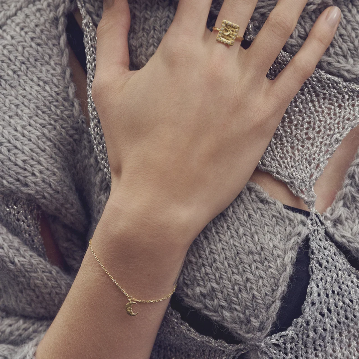 Maanesten Laura gold-plated bracelet shown on wrist, fine gold chain with moon pendant in close-up. Model 8689a-2