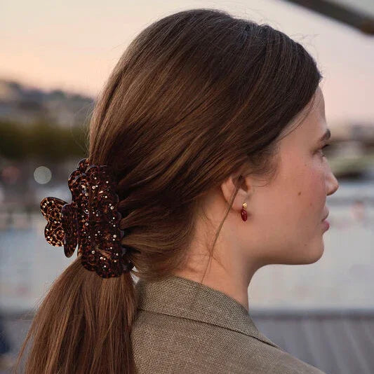 Maanesten Lavinia Hair clip leopard pattern in brown acrylic, worn in long hair outdoors. Model 2026-4206-1.