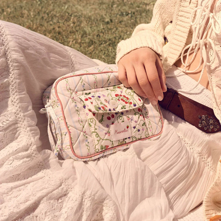 The Maanesten Reva Bag Summer Stripes Blue is shown here in quilted cotton with a floral pattern, worn on a white dress. Model 4131-1
