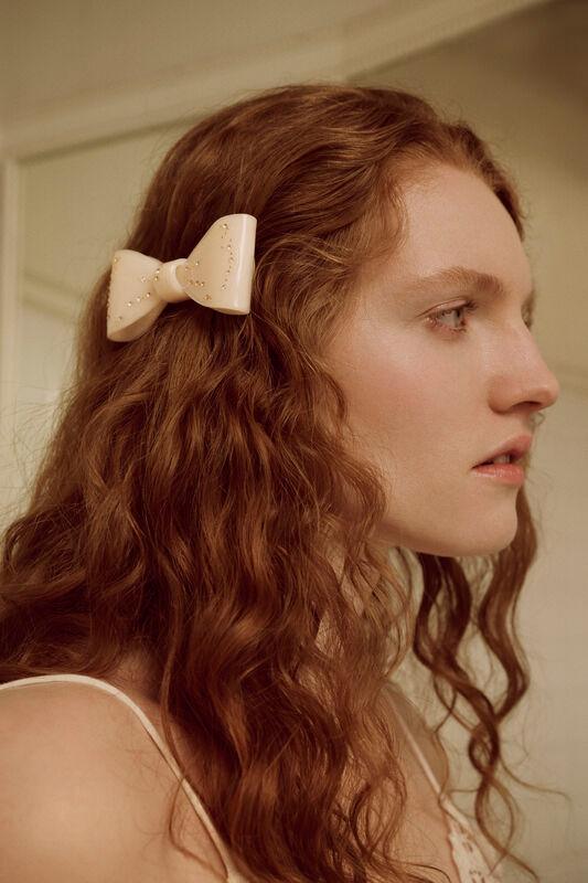 Maanesten Ribin Hair Clip Cream shows a cream colored hair clip in bow shape on long curly hair. Model 3981