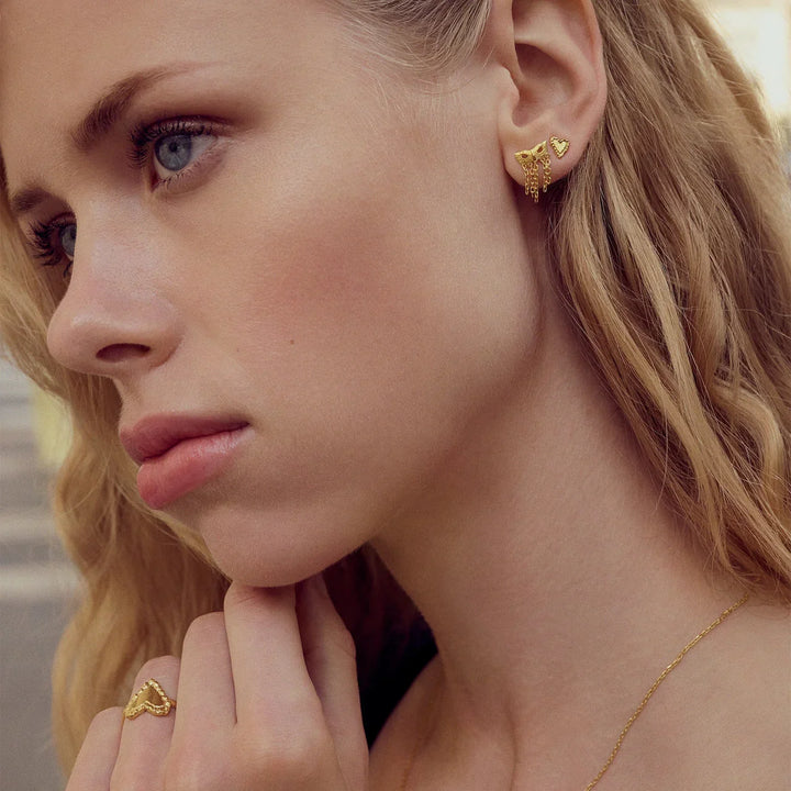 maanesten-rouge-gold-plated-heart studs shown on model, close-up of ear with golden heart studs. Model 10059a-2