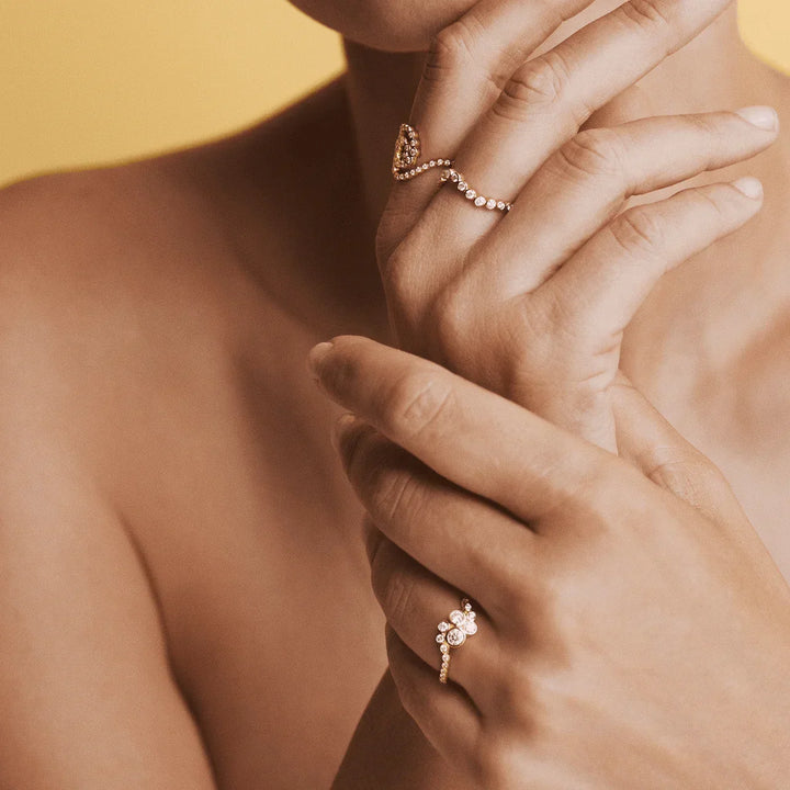 Mads Z Freya 14kt gold ring wave 0.28ct W/SI shown on woman's hand, elegant wave design with diamonds. Model 1541177-001