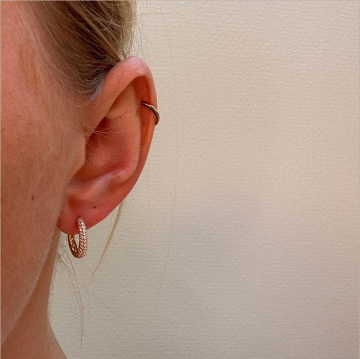 Mads Z La Boheme 8kt gold creole with zirconia appears on the ear, elegant and sparkling. Model 3317030-2