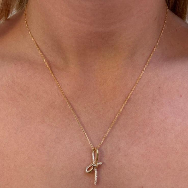Mads Z Miss Butterfly gold bow pendant with diamonds worn around the neck. Model 1531003-2