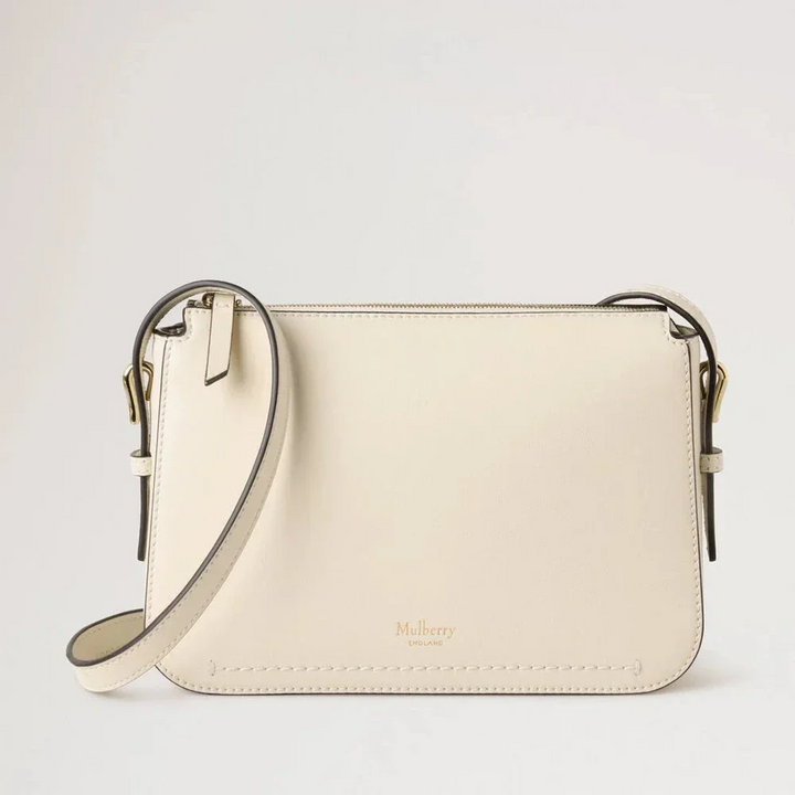 Mulberry Clovelly Pouch Micro Classic Grain Eggshell shows a small light leather clutch with adjustable strap. Model RL8729587H687.