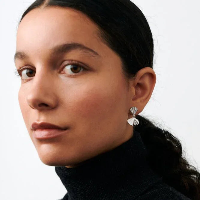 Pernille Corydon Autumn Leaf earrings in silver are shown worn by a woman with dark hair. Model e-497-s.
