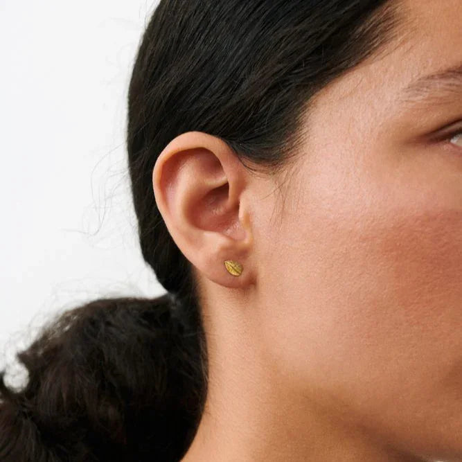 Pernille Corydon Elm Leaf ear studs in gilt can be seen on the ear, discreet leaf-shaped detail. Model E-329-GP