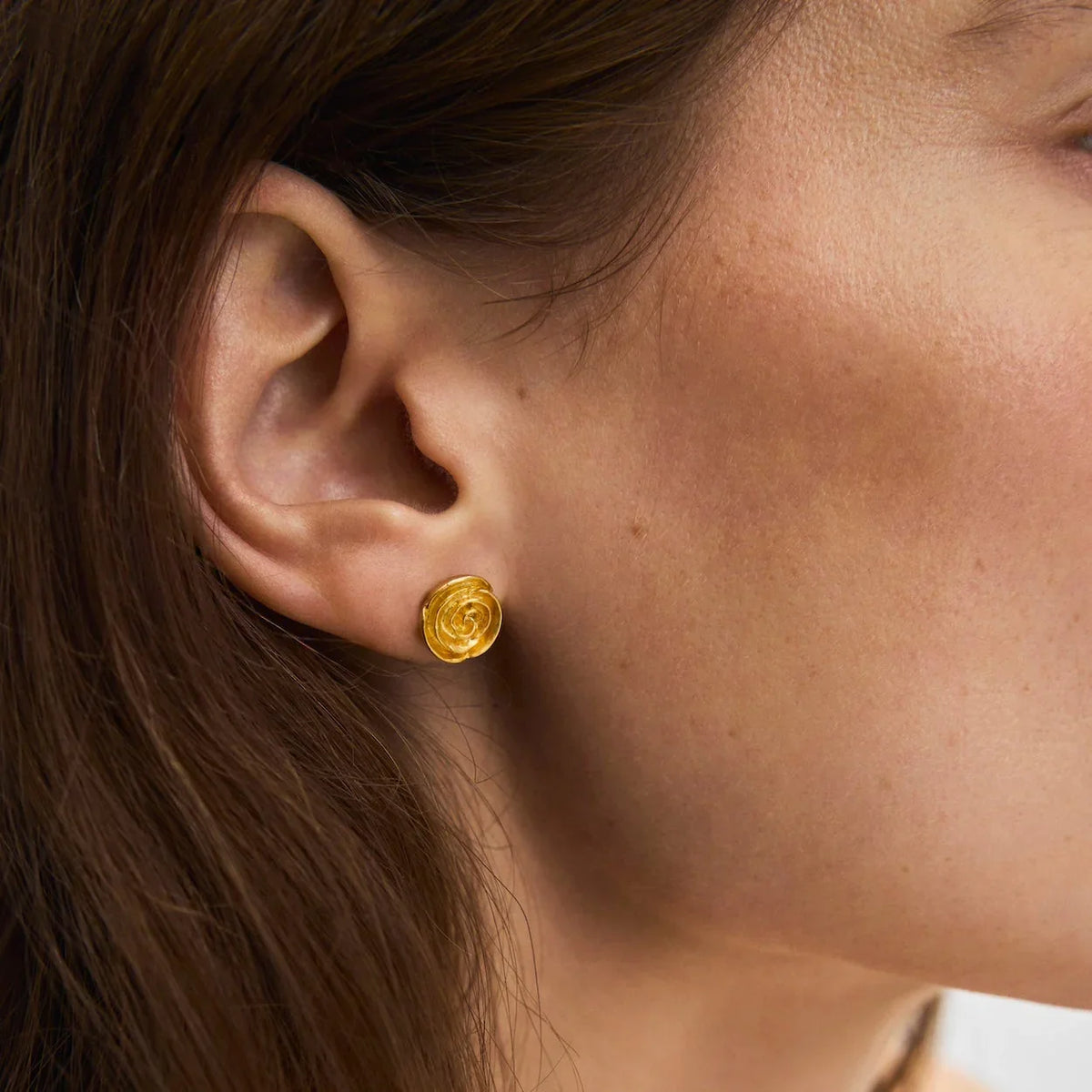 Pernille Corydon Medium Rose gold plated stud earrings shown close to ear, elegant gold colored detail. Model E-536-GP-1