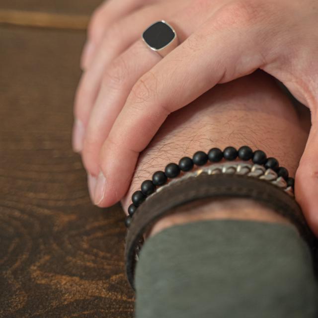 Son of Noa men's ring in silver with onyx worn on hand close to leather bracelet, Model 106700009-001