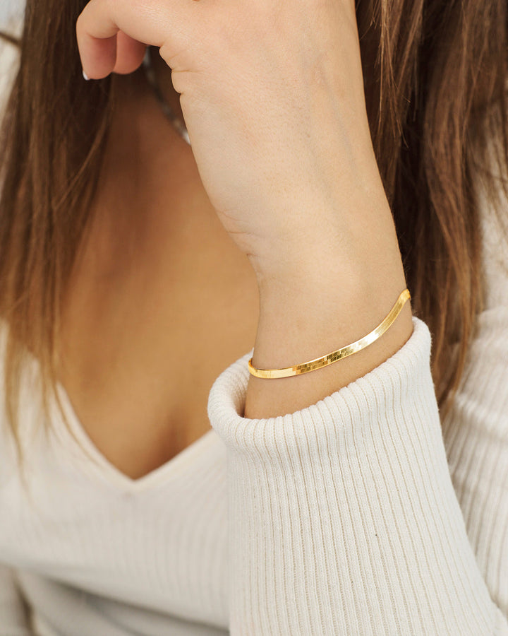 Studio Z Cobra Bracelet in gold-plated silver appears on a woman's hand with simple, elegant style. Model 7250319.