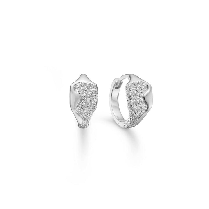 Studio Z Edge Silver Creoles shows a pair of silver earrings with an organic texture and glossy surface. Model 7110891-1