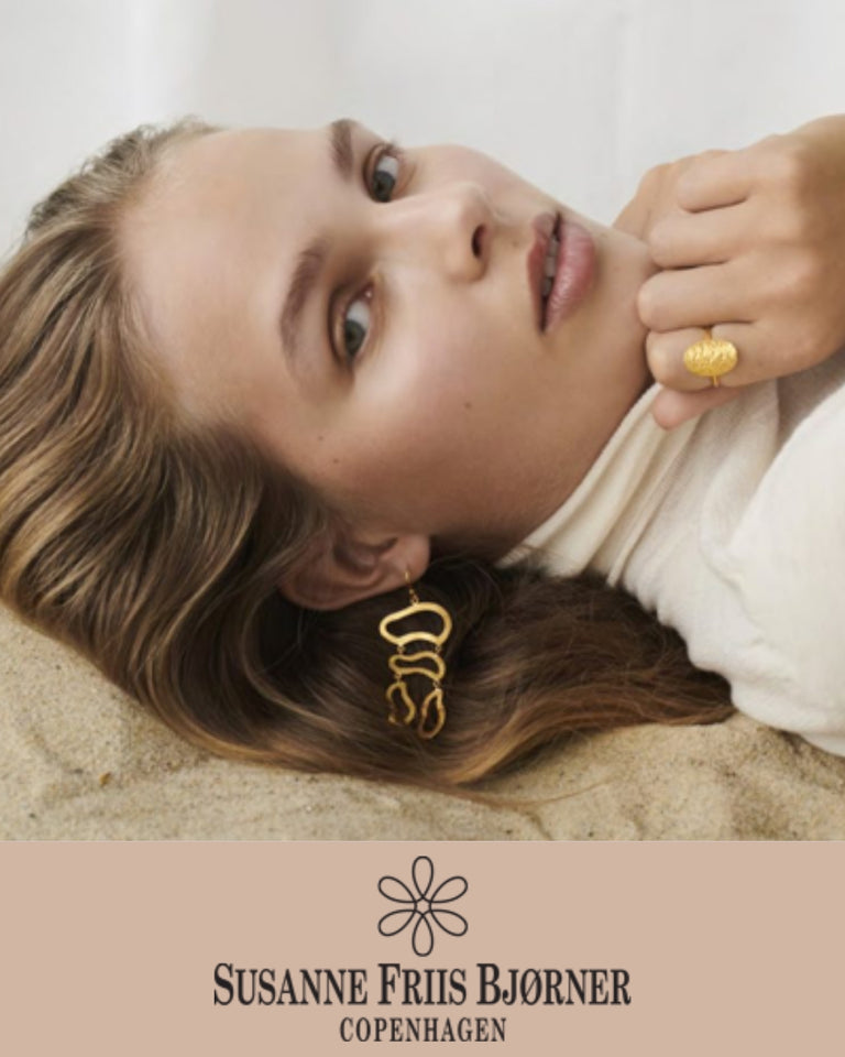 Susanne Friis Bjørner guld ørering og ring, modelbillede med kvinde iført smykker, forside
