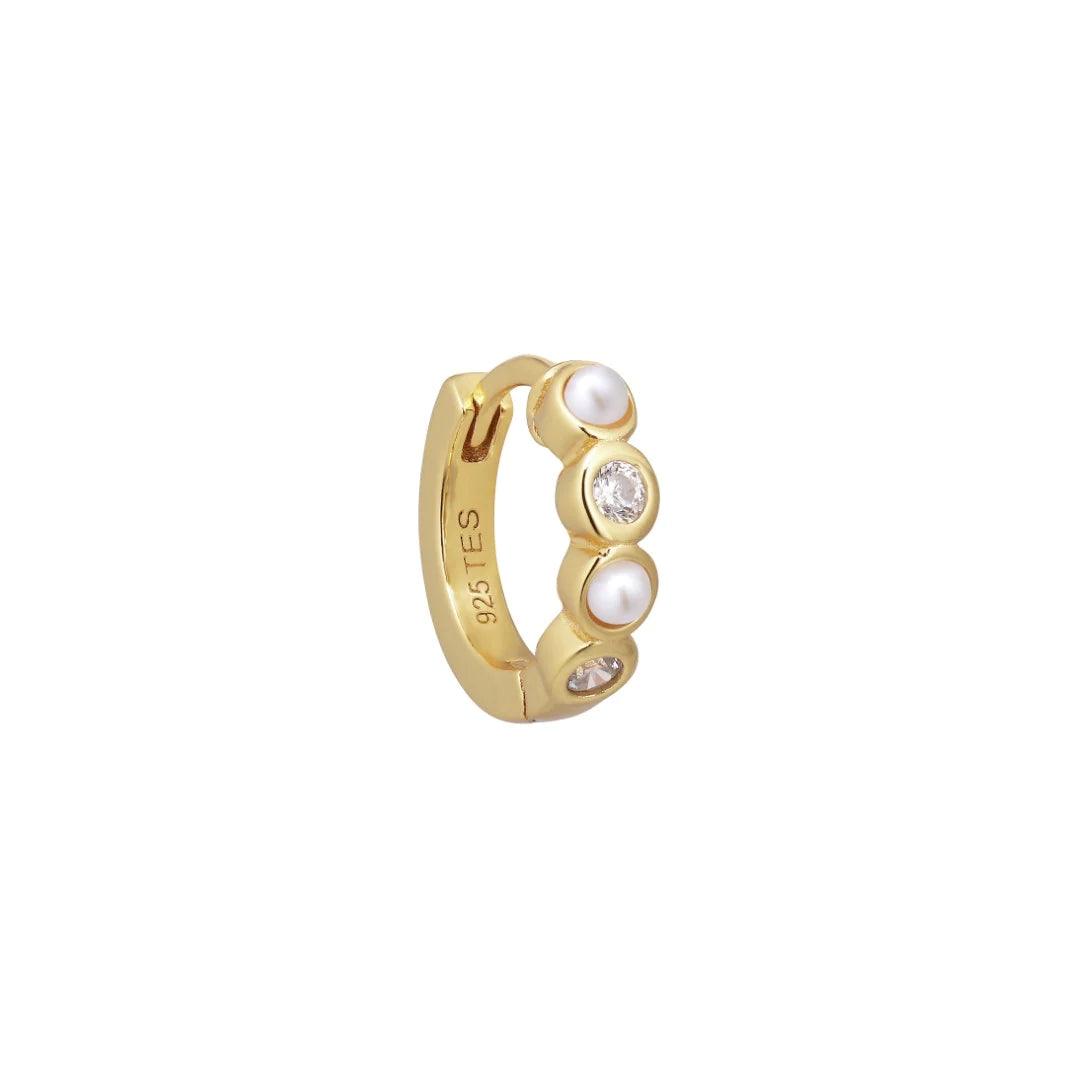 Ellie Huggie Pearlwhite shows a gold-plated earring with small white pearls and clear stones, Model FW2308.
