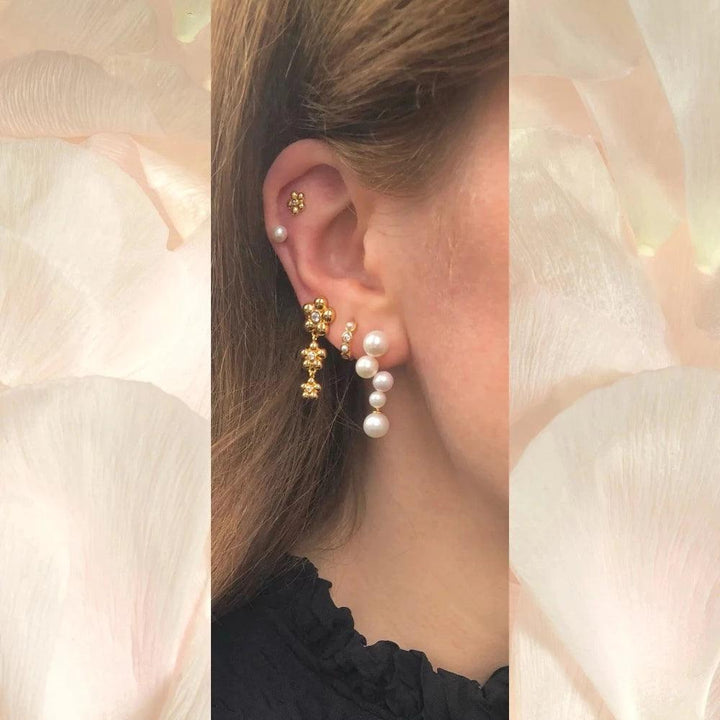 Paloma Stud shown in ear of woman with multiple earrings, gold and pearls, Model FW2309-2.