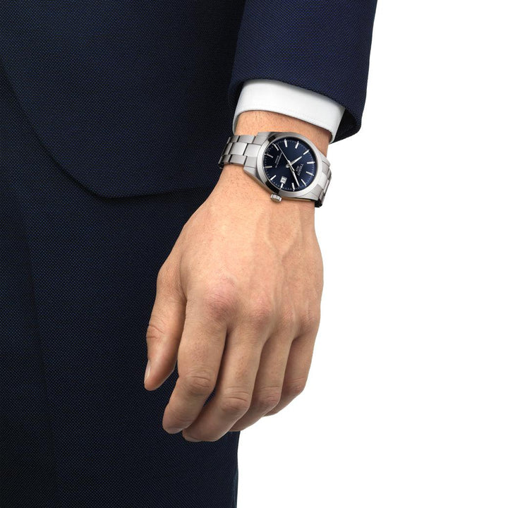 Tissot Gentleman Powermatic 80 Silicon is seen on wrist with blue dial and steel chain. Model T1274071104100