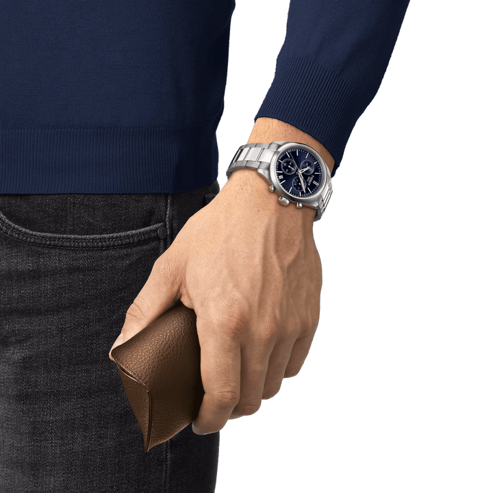 Tissot PR 100 Chronograph with blue dial on wrist, steel strap and brown case, Model T1504171104100.