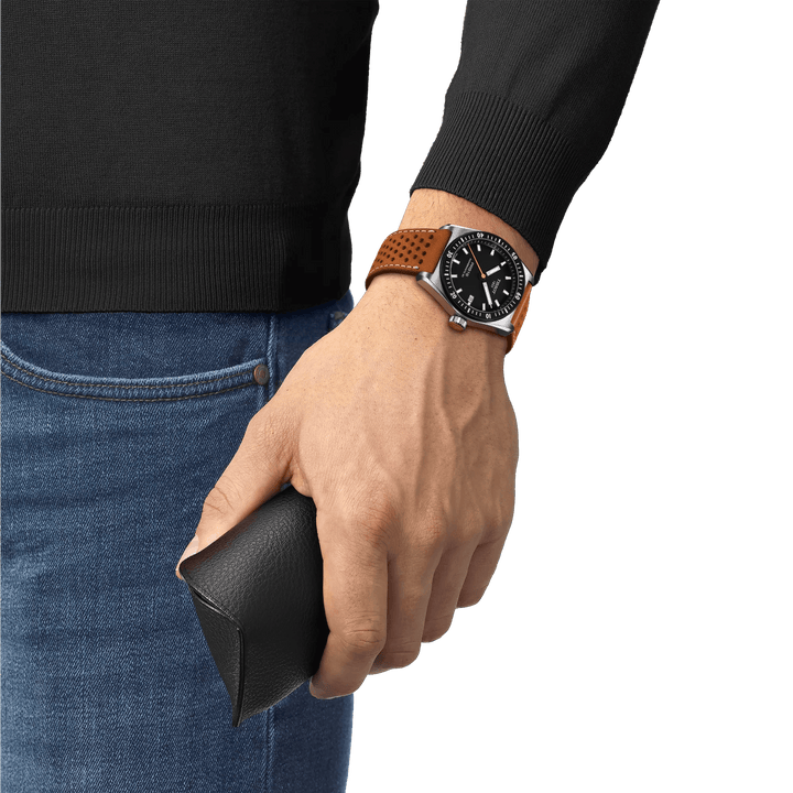 Tissot PR516 Powermatic 80 is worn on the wrist, black dial and brown leather strap. Model T1494071605100
