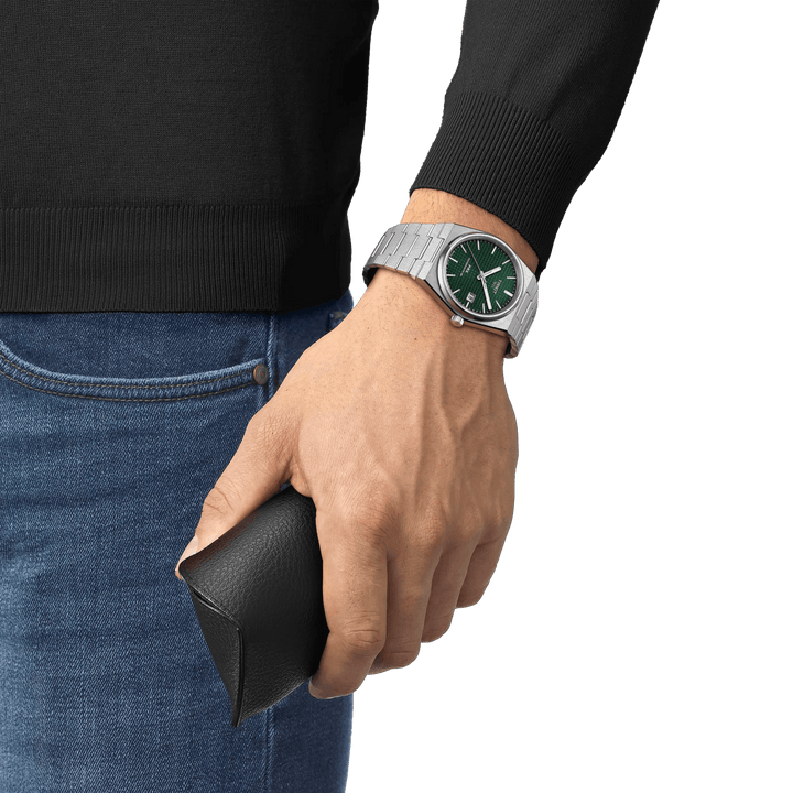Tissot PRX Powermatic 80 with green dial on wrist, steel chain, relaxed in jeans. Model T1374071109100