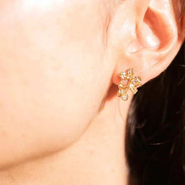 Vincent ilium earrings gold plated with white crystals shown on ear, organic golden shape. Model VJ241-UEG-1.