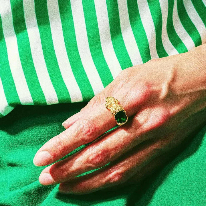 Vincent Stolen Possession Ring gold-plated ring with large green stone, worn on hand. Model VJ103-URG-001